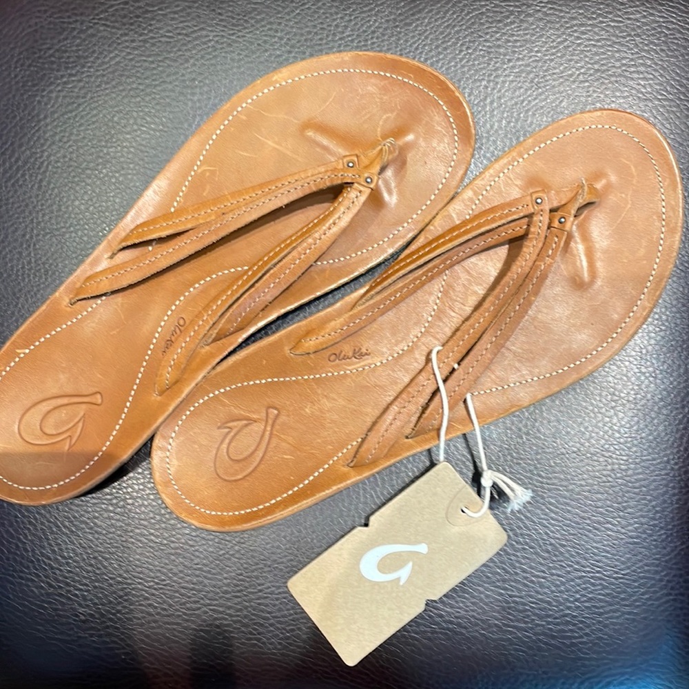 New- Olukai leather U’I flip flops. Color is Sahara